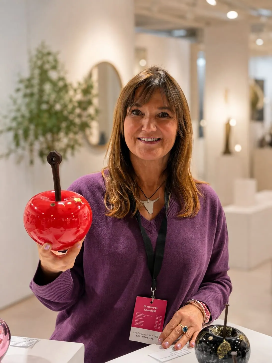 Elzbieta Larsten holding a red glass apple